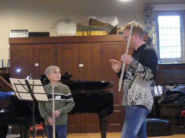 A teacher giving flute tuition to a child